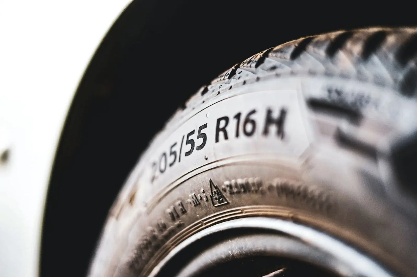 
              Close up of a tire and wheel on a car showing its rating