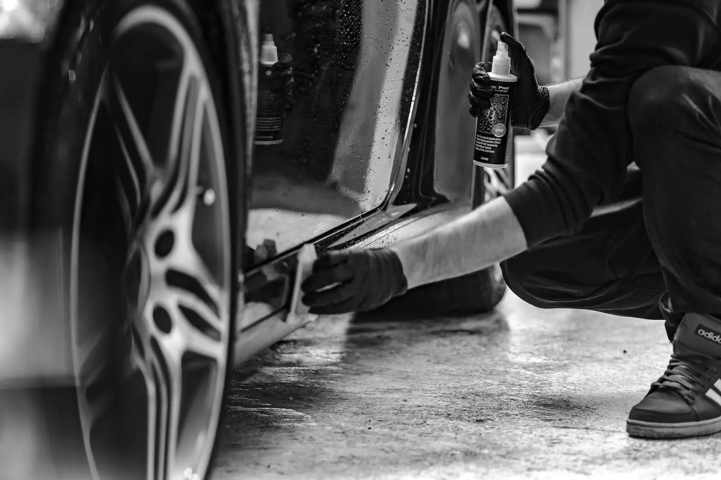 
              Man using sandpaper to wet sand the runner on a car.