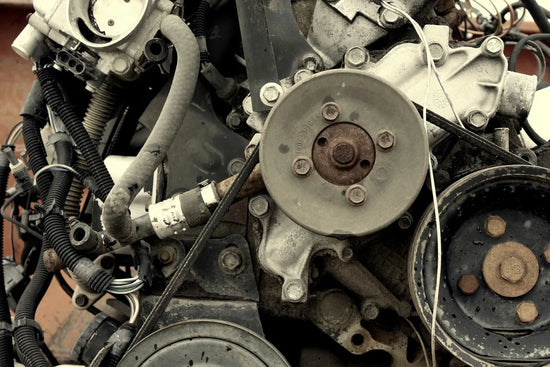 Pulleys and hoses on the front of a car engine.